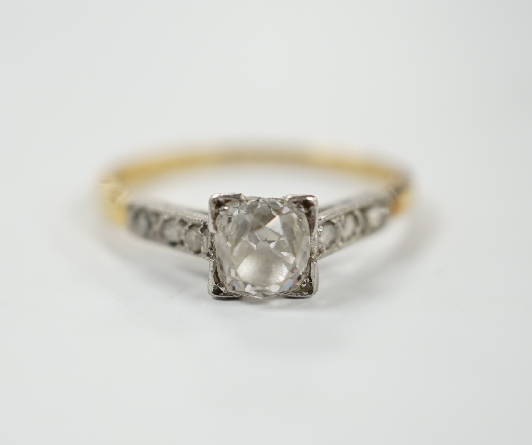 A 1920's yellow metal and single stone old mine cut diamond set ring, with six stone diamond set shoulders, size K/L, gross weight 2.2 grams.